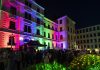 TU Chemnitz lädt zur TUCsommernacht ein Bunt angestrahlte Fassade eines Gebäudes, davor tanzende Menschen